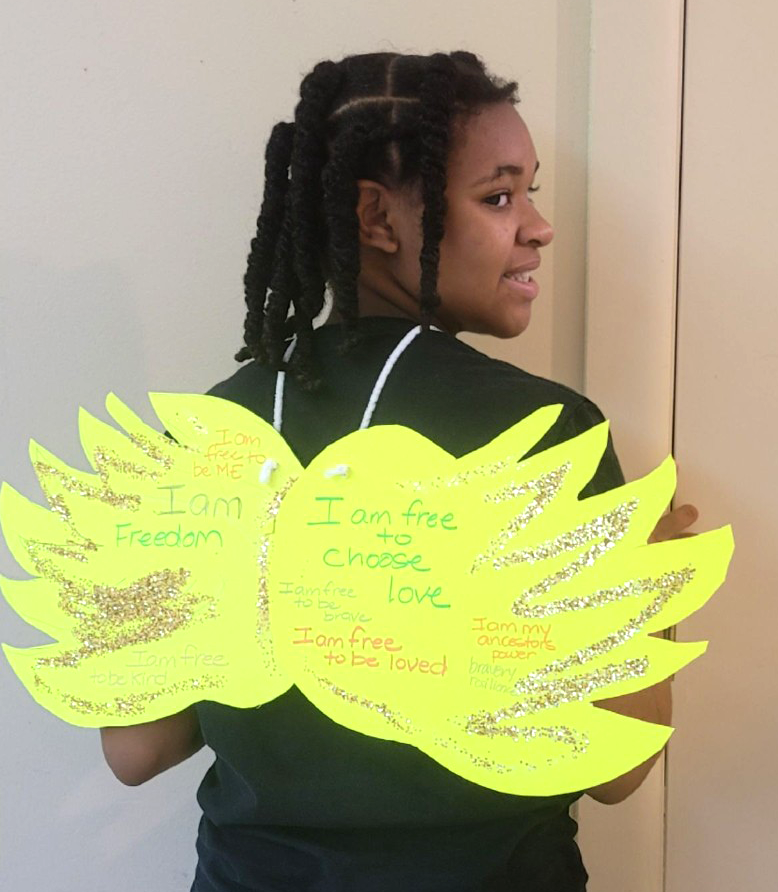 Teen wearing gold wings - art project